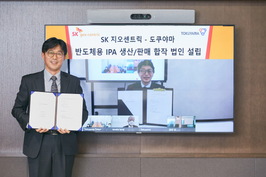 최안섭(왼쪽) SK지오센트릭 전략본부장과 노무라 히로시 도쿠야마 전자재료부문장이 합작법인 설립 계약서를 들고 기념사진을 촬영하고 있다. <SK지오센트릭 제공>